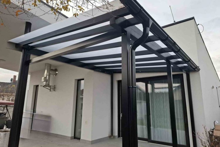 Pergola na terasu s čiernou hliníkovou konštrukciou a polykarbonátovou strechou napojená na rodinný dom, hormax