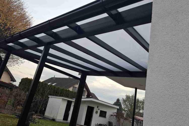 Pergola na terasu s čiernou hliníkovou konštrukciou a polykarbonátovou strechou napojená na rodinný dom, hormax