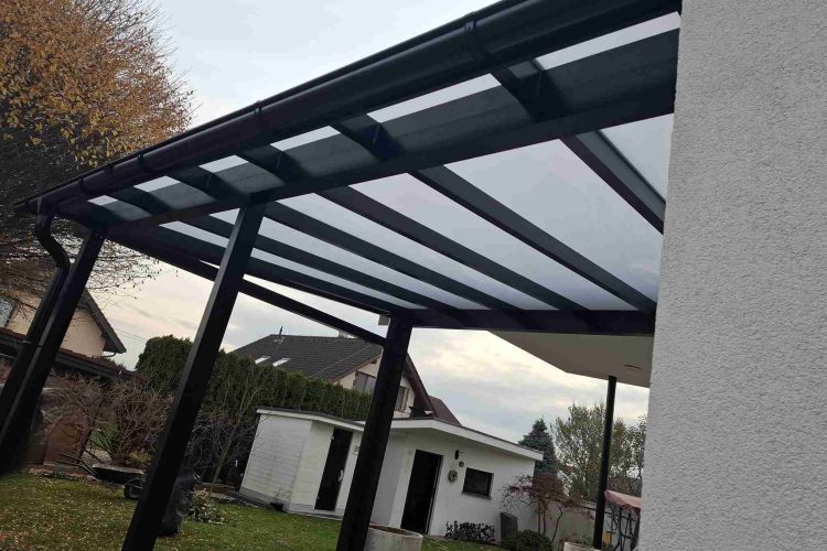 Pergola na terasu s čiernou hliníkovou konštrukciou a polykarbonátovou strechou napojená na rodinný dom, hormax